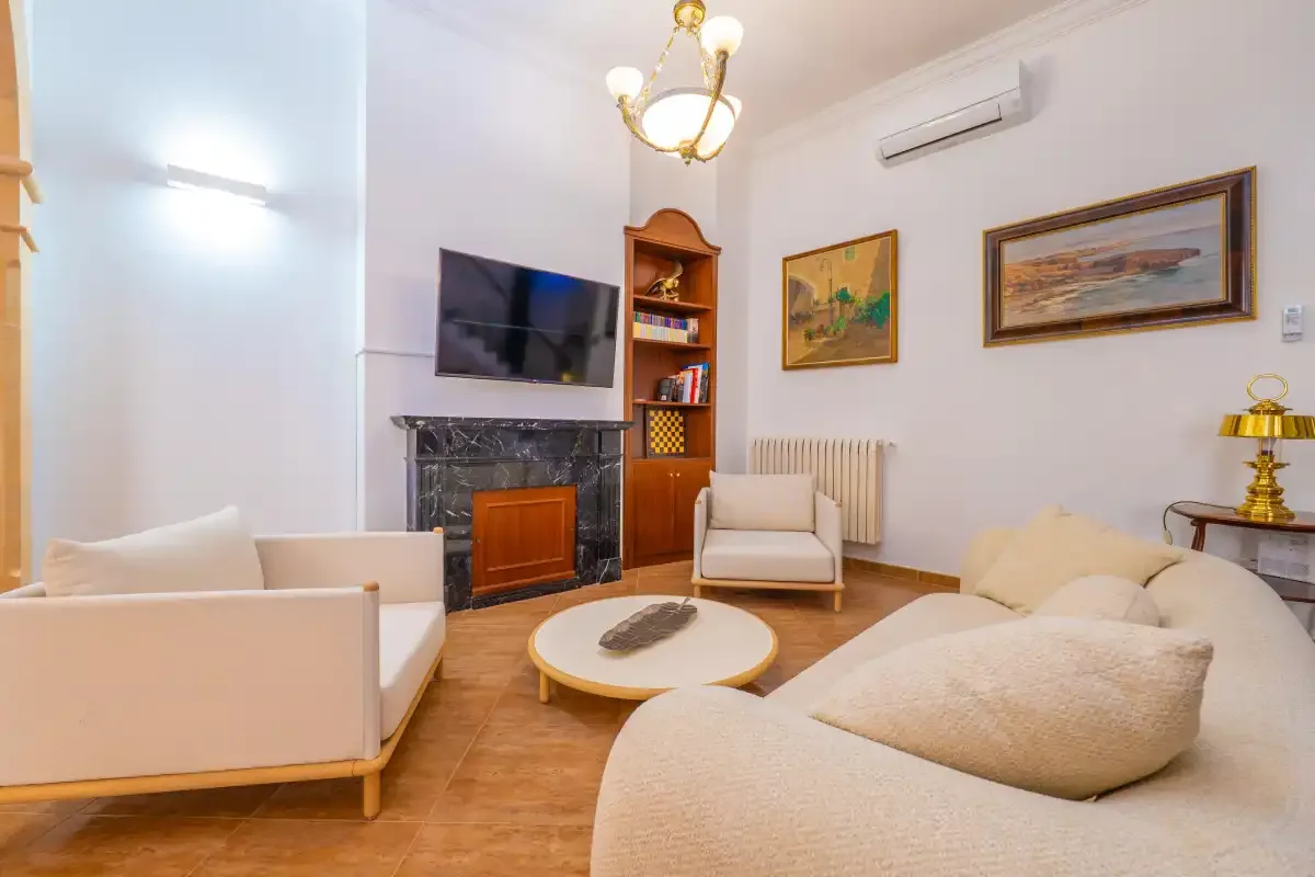 Una sala de estar con asientos alrededor de una mesa de centro y una chimenea.