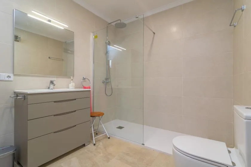 Un baño con lavabo, espejo y ducha de vidrio.