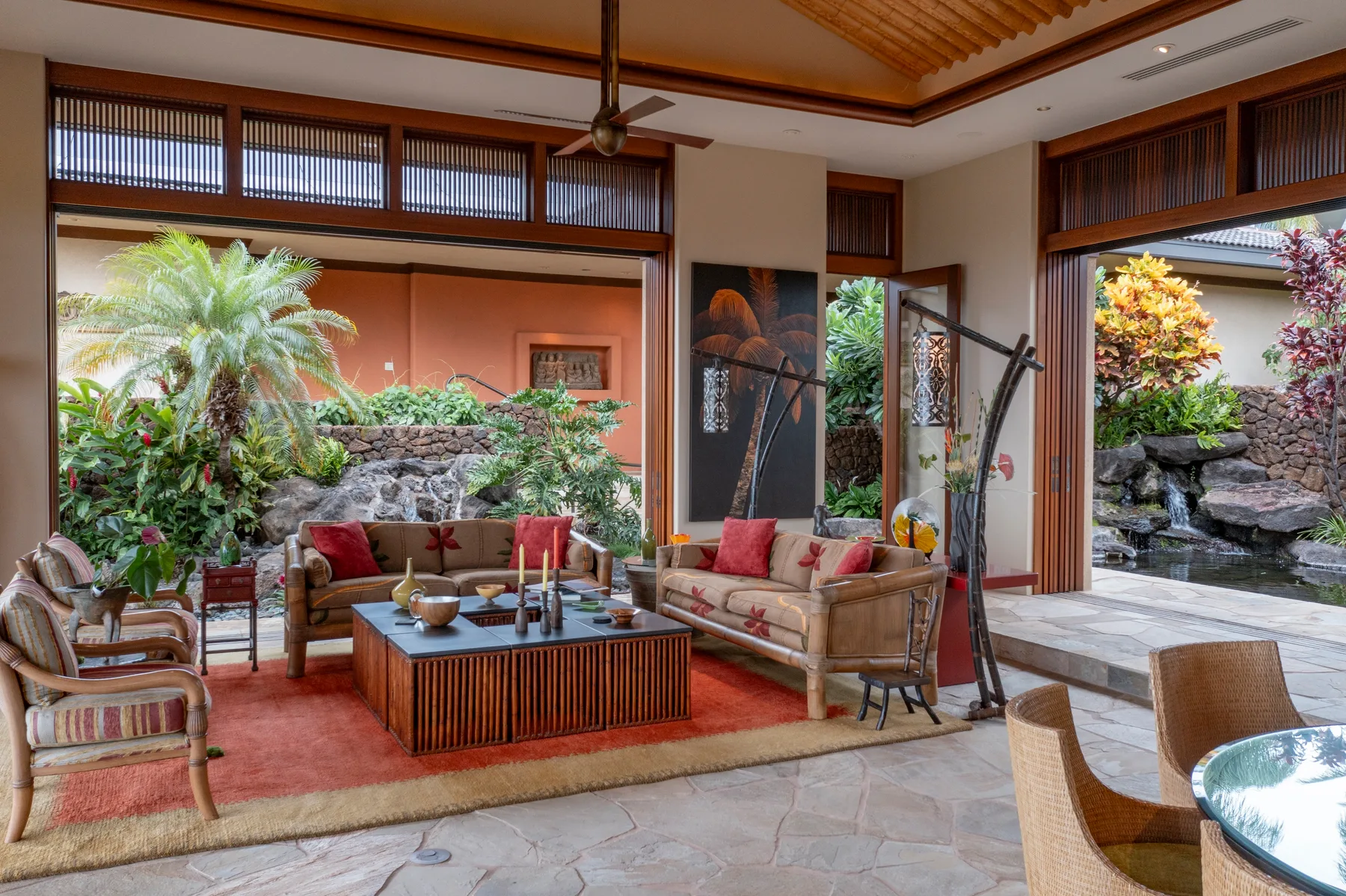 Sala abierta con asientos alrededor de una mesa baja y vistas al jardín.