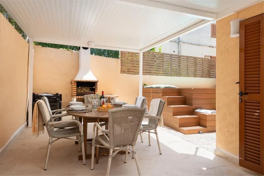 Comedor en un patio cubierto con mesa, asientos y escalones integrados.