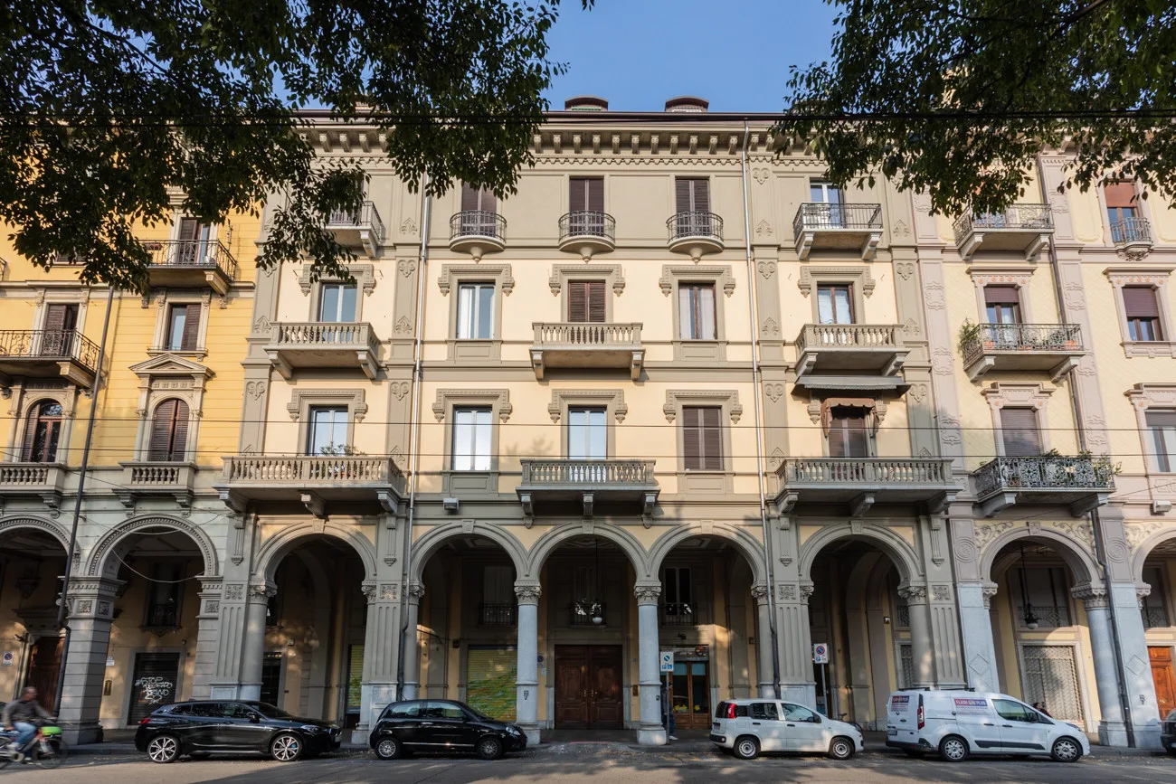 A multi-story building with arched ground-floor openings and balconies above.