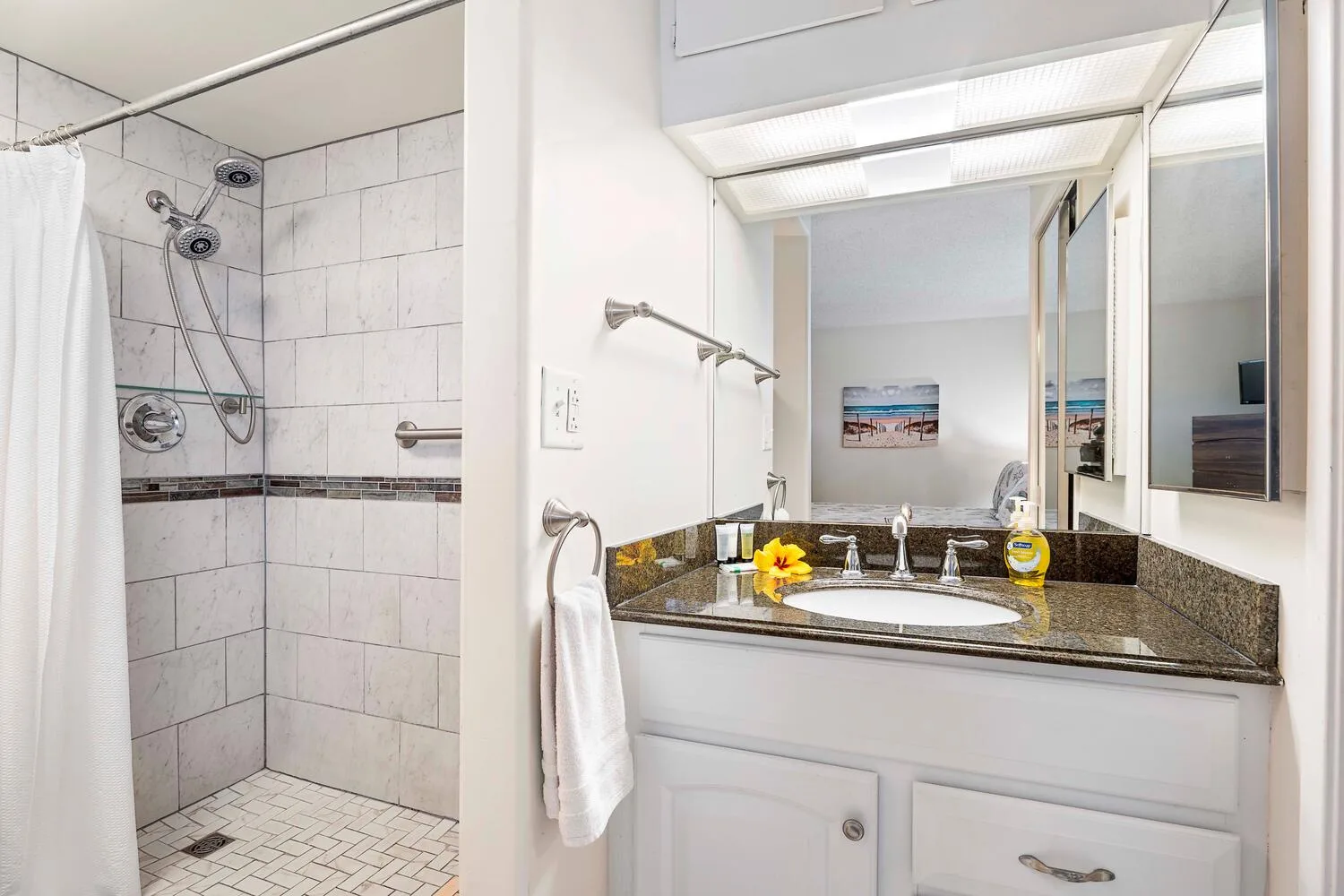 A bathroom vanity with a sink and a tiled shower.