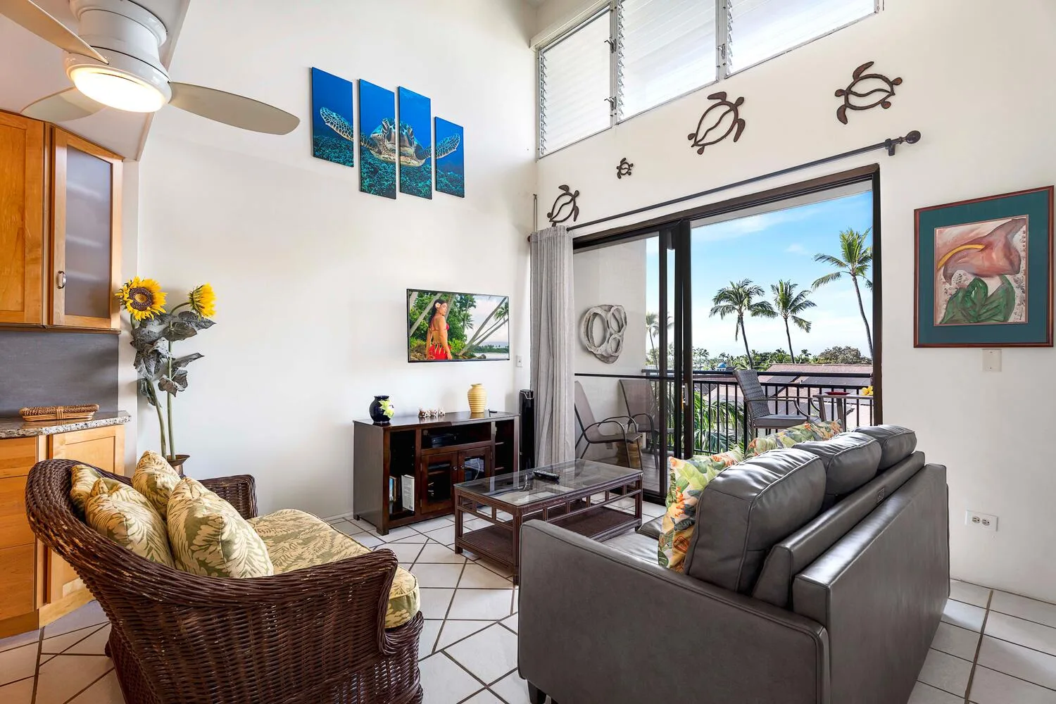 A bright living room opens onto a balcony through wide sliding glass doors.