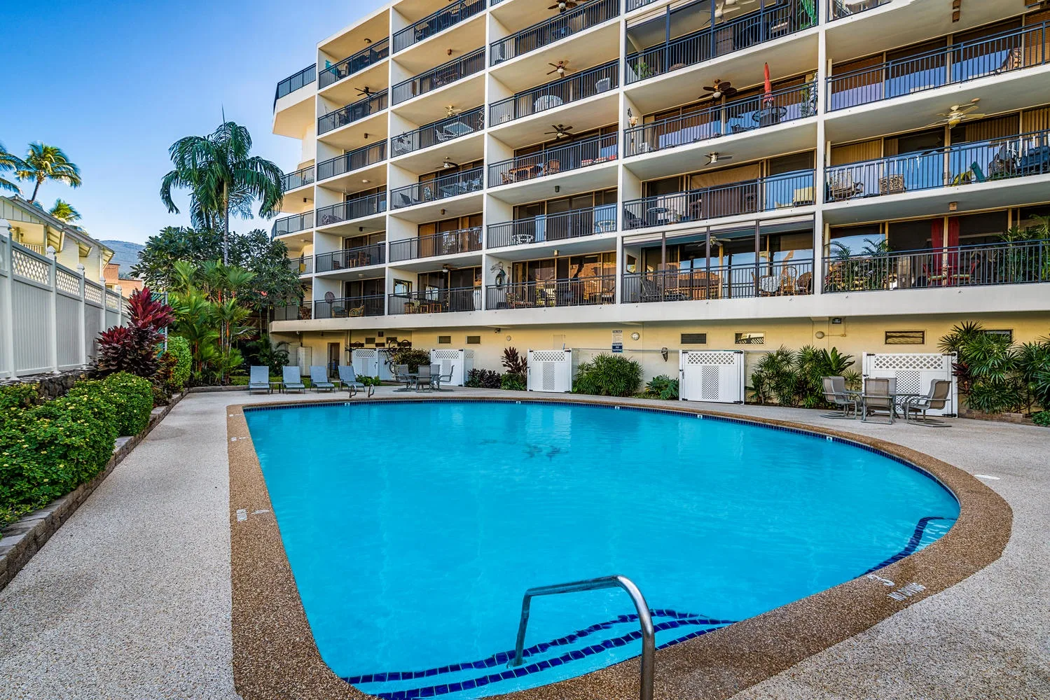 Una piscina está junto a un edificio de apartamentos de varias plantas.