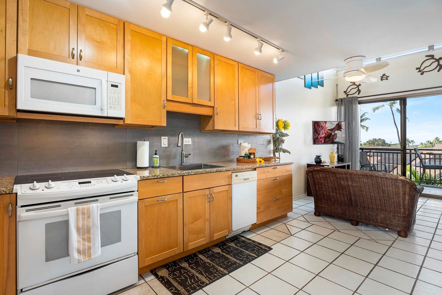 A kitchen with wooden cabinets and a dining area beside large windows.