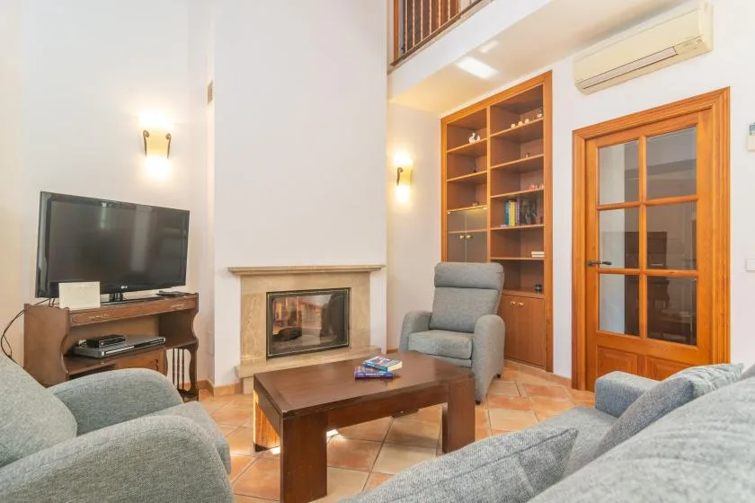 Una sala de estar con asientos, una mesa de centro, un televisor y una chimenea.