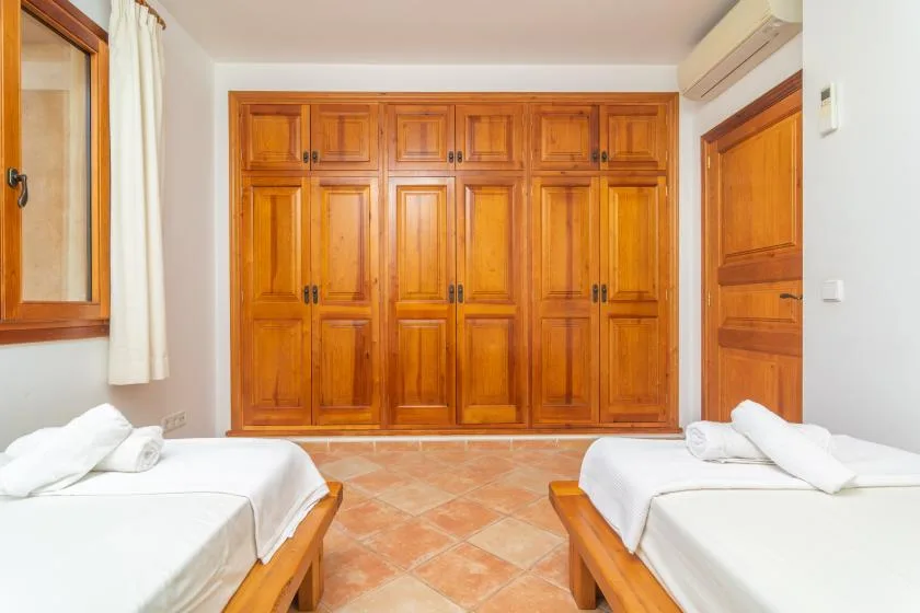 Un dormitorio con dos camas frente a una pared de armarios de madera.
