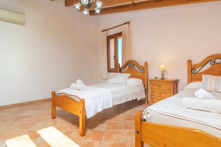 Dormitorio con dos camas de madera y una mesita de noche.