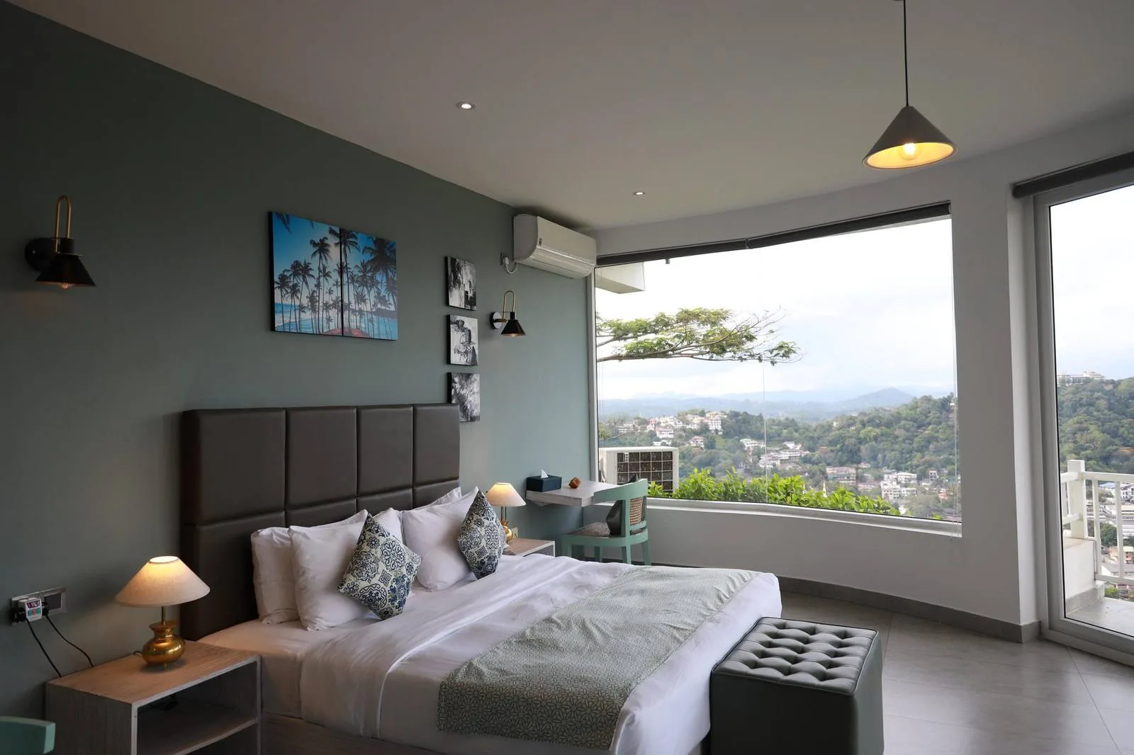 Habitación deluxe con una ventana panorámica esquinera con vistas a la ciudad de Kandy y las colinas de Hanthana