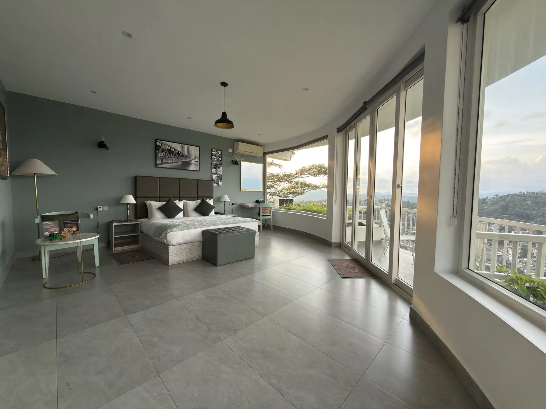 Habitación con cama king y ventanas panorámicas curvas con vistas a Kandy