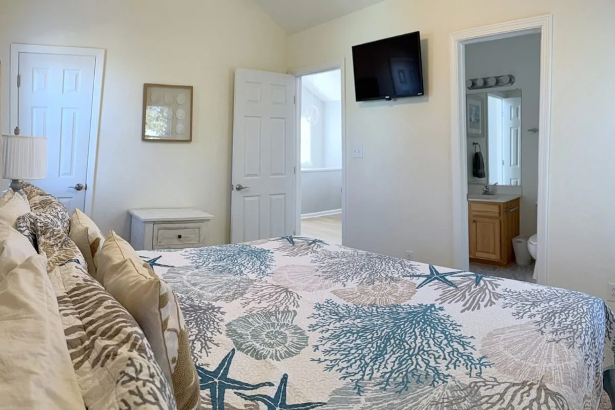 Un dormitorio con una cama cubierta con una colcha estampada azul y blanca.