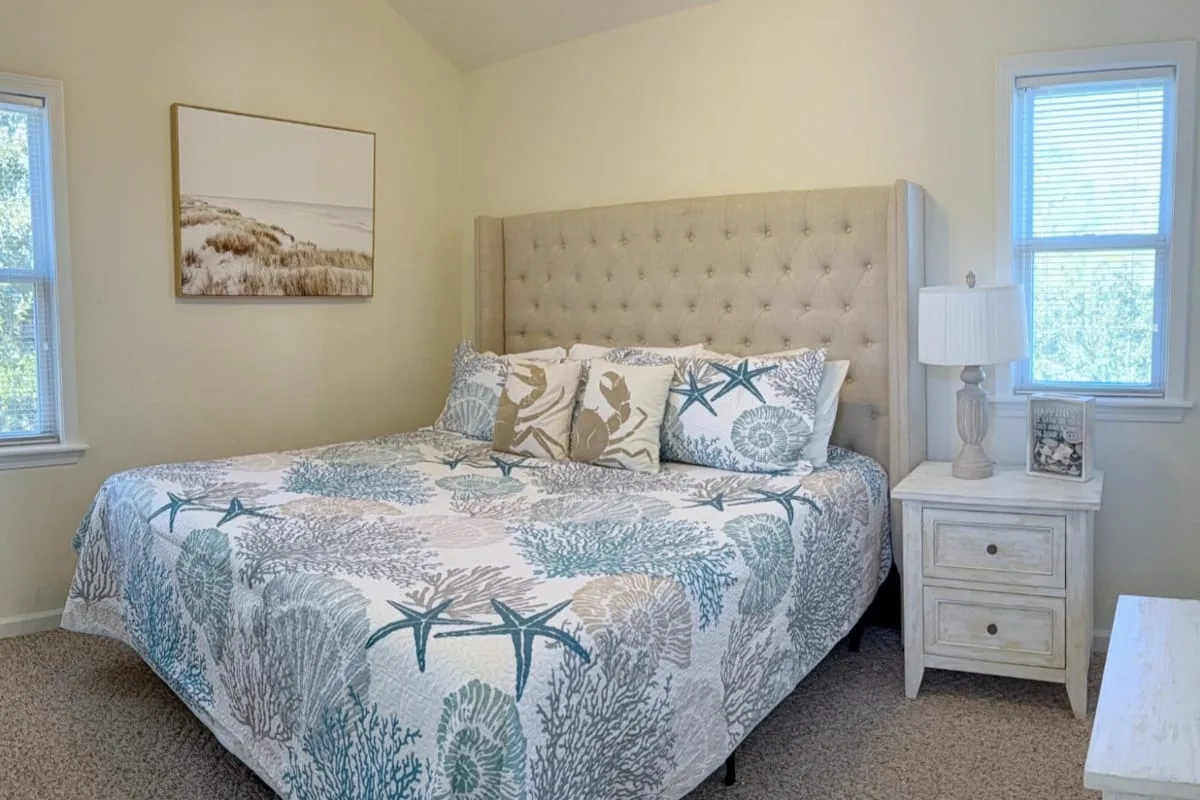 A bedroom with a large bed dressed in blue and white patterned bedding.