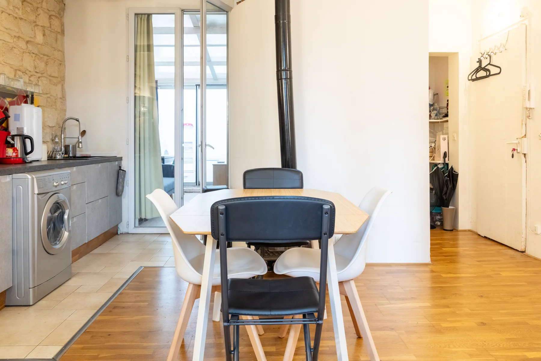Comedor con una mesa y sillas junto a una cocina compacta.