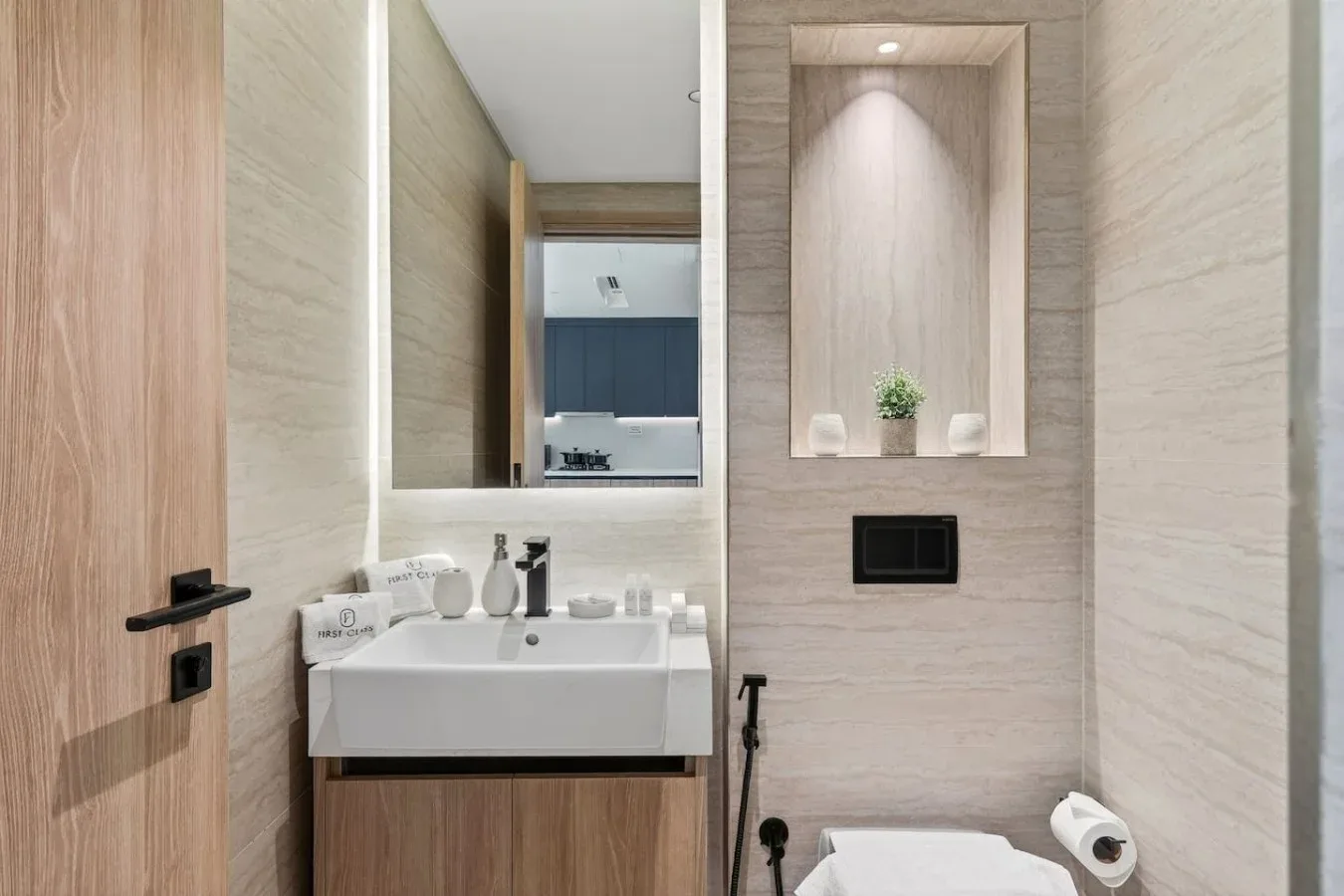 A bathroom vanity and sink sit beside a recessed display niche.