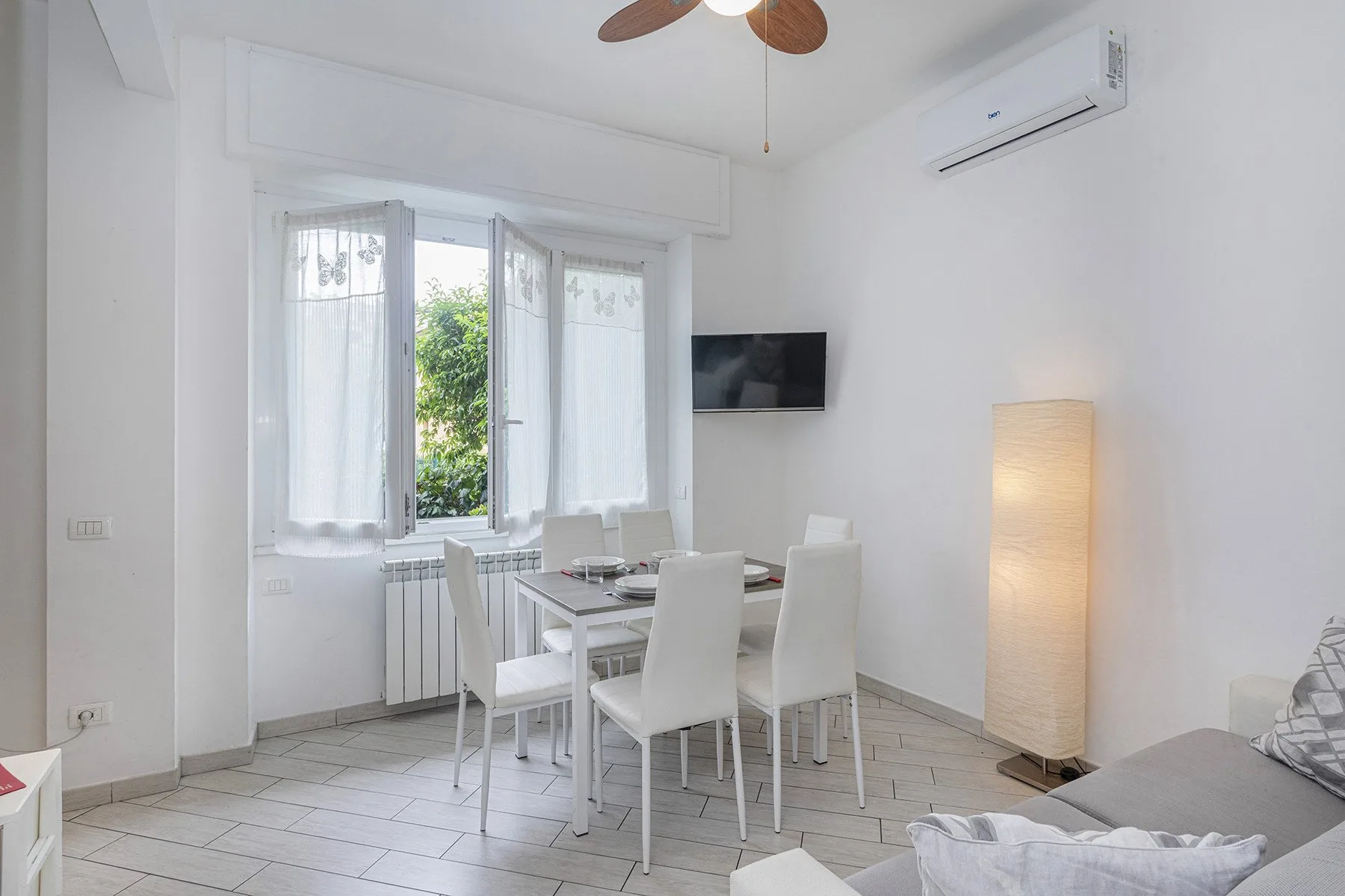 Un comedor luminoso con una mesa y sillas junto a ventanas con cortinas.