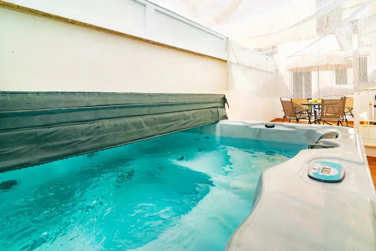 Una piscina interior de agua turquesa con una pequeña zona de asientos cerca.