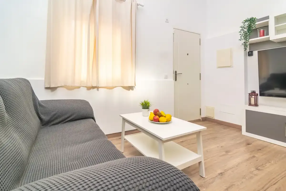 Una sala de estar con asientos, una mesa de centro y un televisor.
