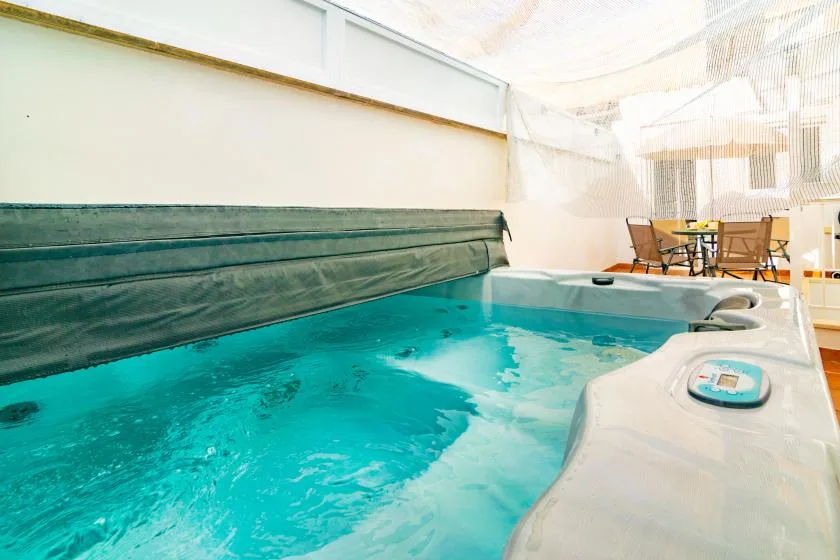 An indoor hot tub with bubbling water and a covered seating area nearby.