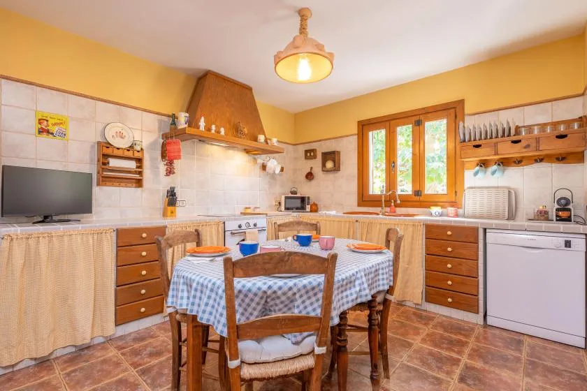 A kitchen dining area with a table, wooden cabinets, and a window.