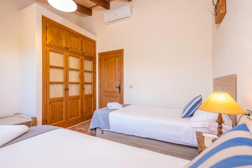 A bedroom with two beds and wooden doors.