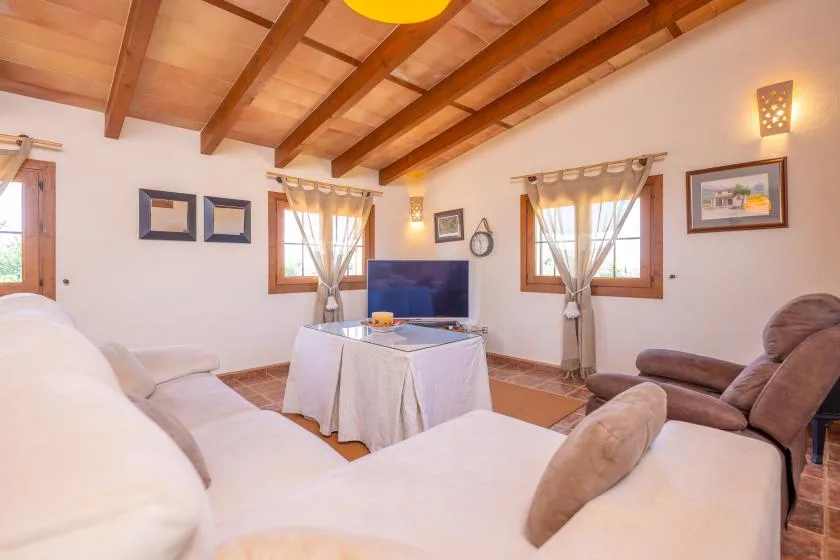 A living room with seating around a television and a covered table.