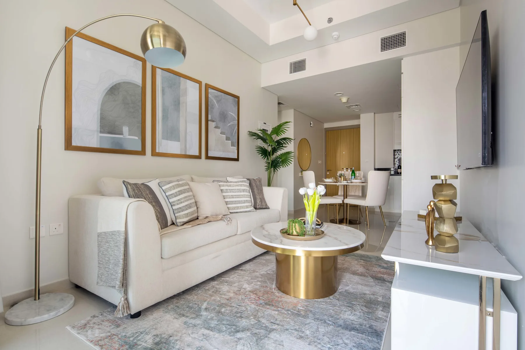 A bright living room with a sofa, coffee table, and framed artwork.