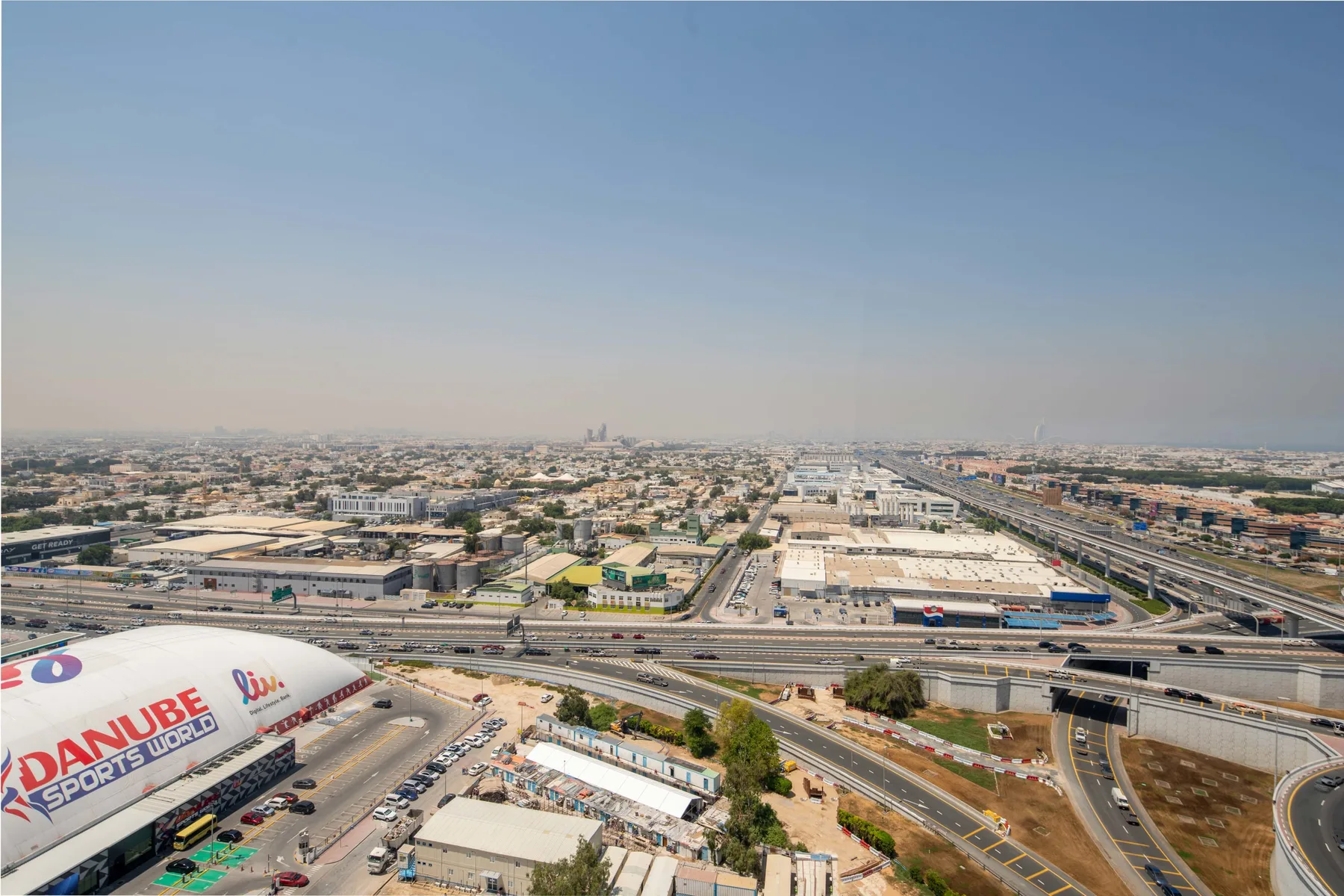 Aerial view of a sprawling city with highways and low-rise buildings.