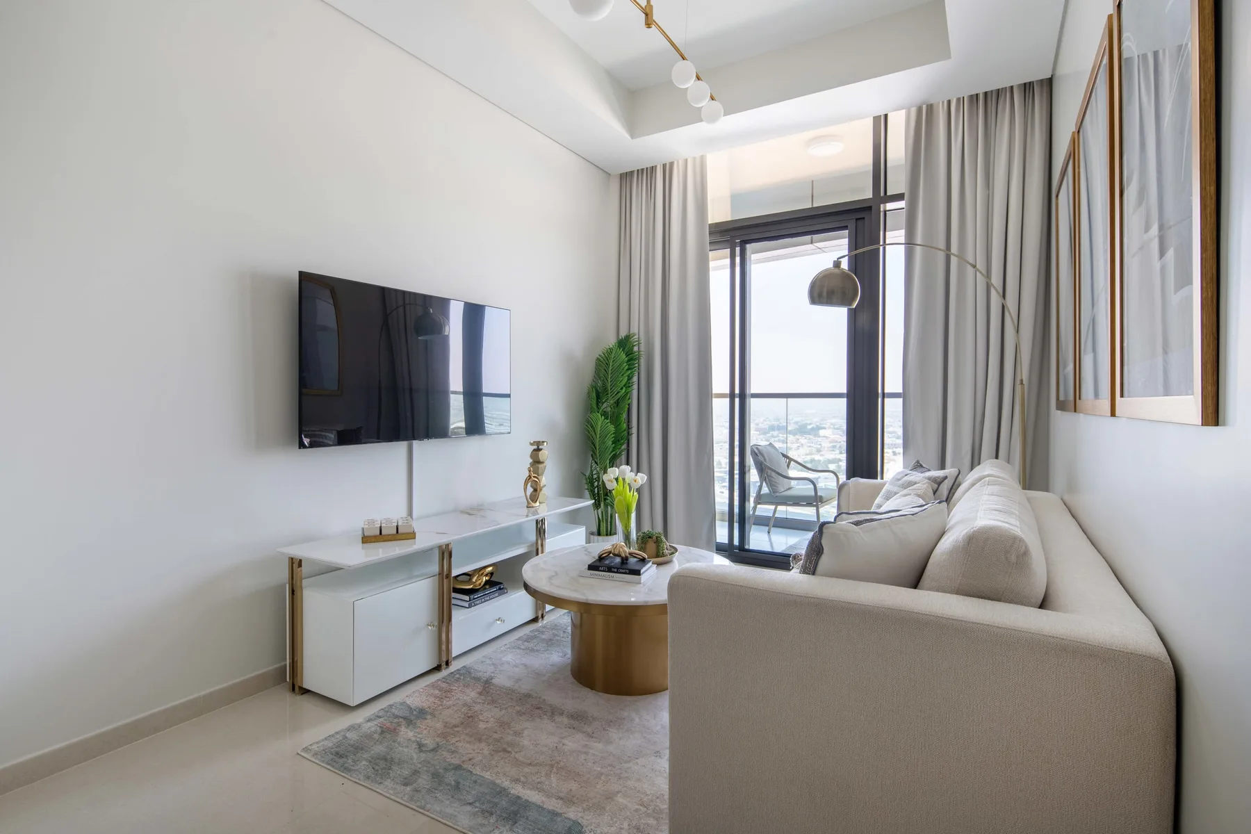 A bright living room with a seating area, coffee table, and television.