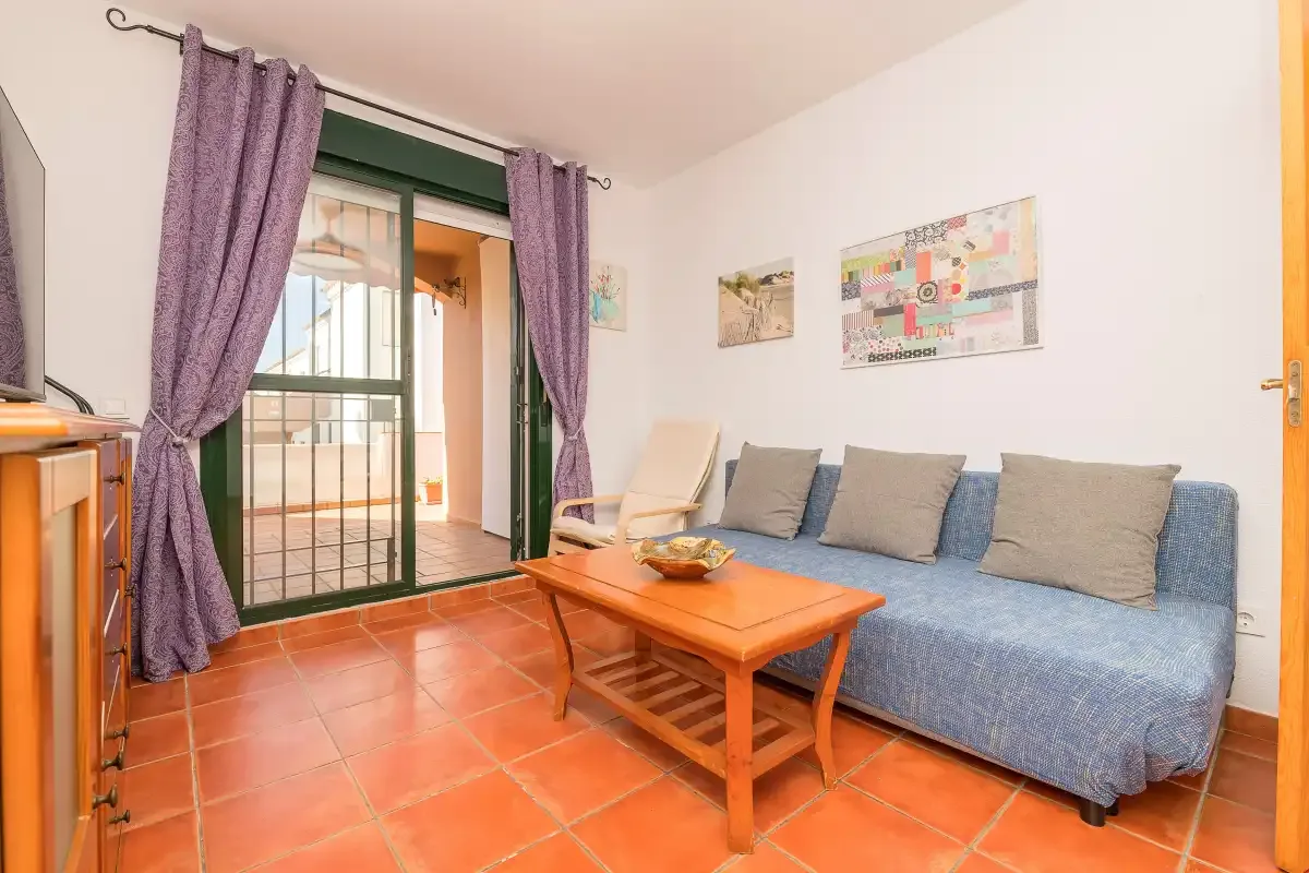 Una sala de estar con un sofá cubierto de azul y una mesa de centro de madera.