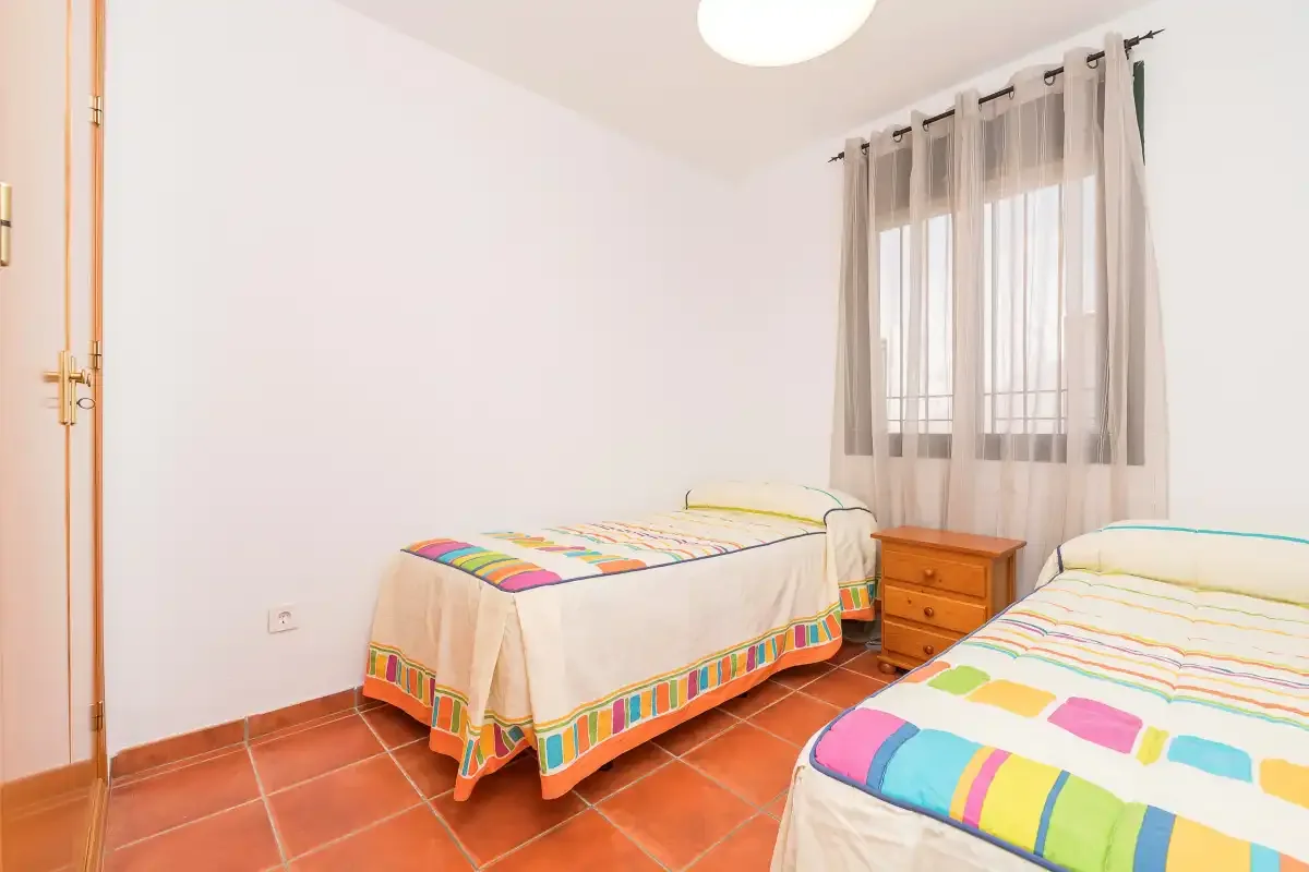 Un dormitorio con dos camas cubiertas con ropa de cama colorida.