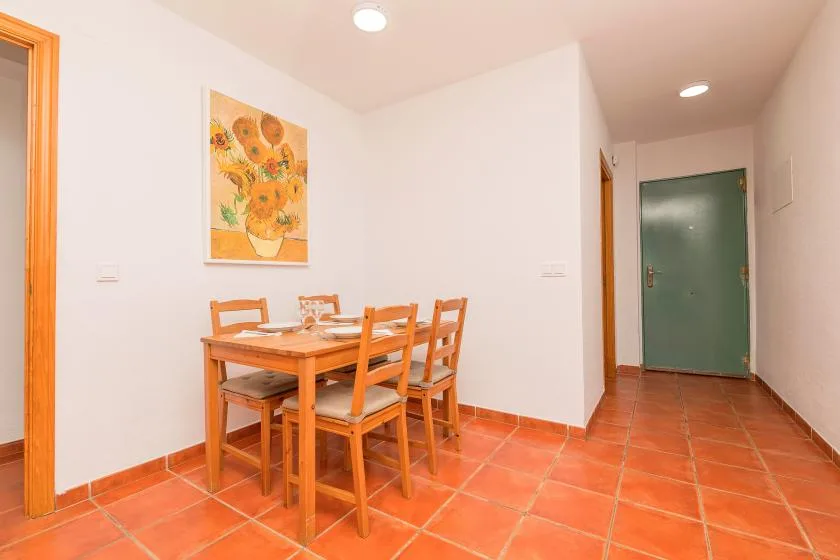 Comedor con una mesa de madera y sillas junto a un pasillo.
