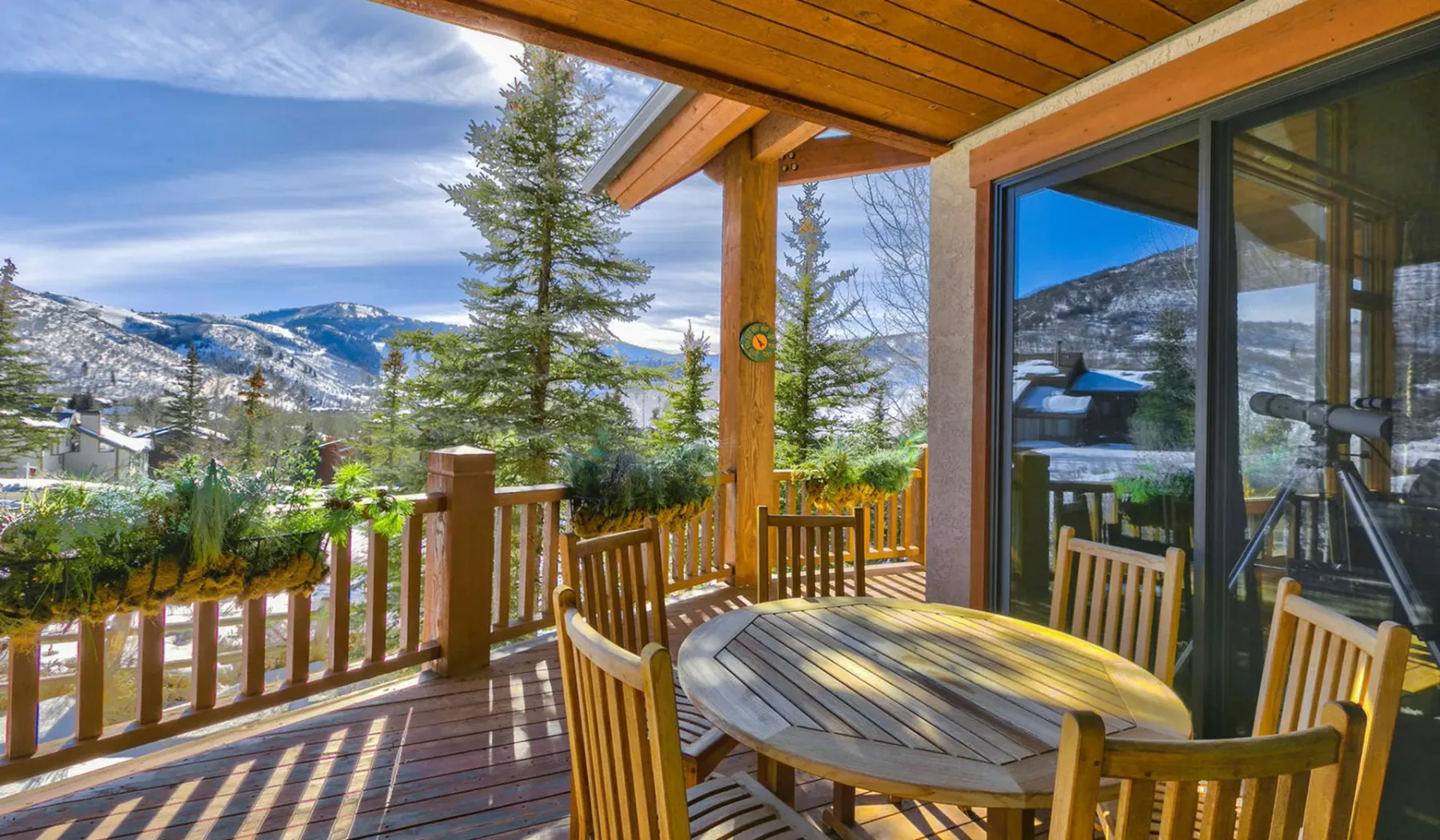 Una terraza de madera con asientos al aire libre tiene vistas a un paisaje montañoso.