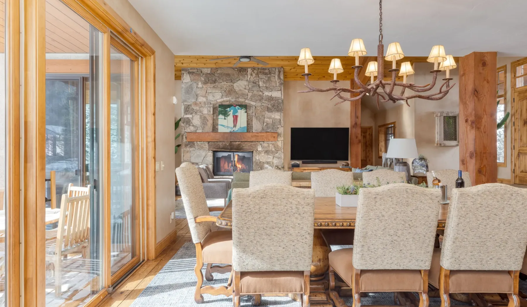 Comedor con asientos tapizados, una chimenea de piedra y un televisor.