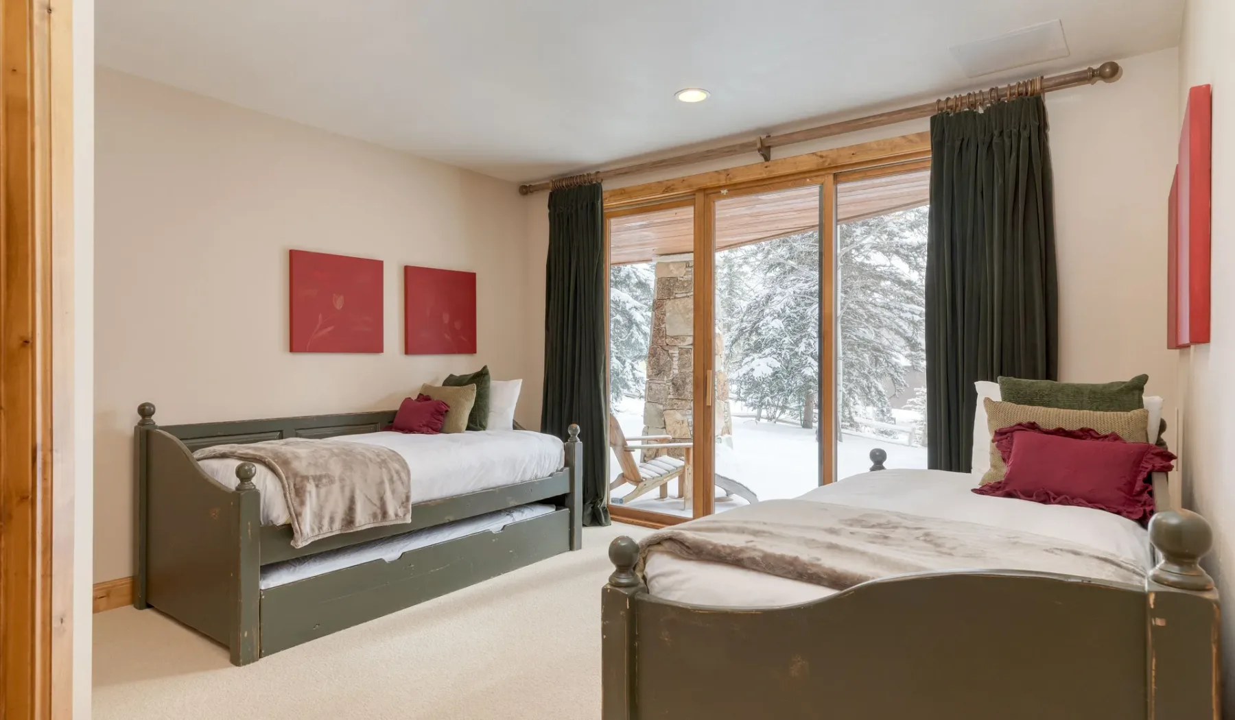 Un dormitorio con dos camas y grandes ventanas con vistas a un paisaje nevado.