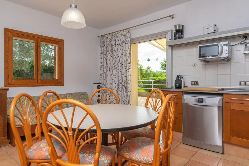 A dining area with a table and chairs beside a kitchen.