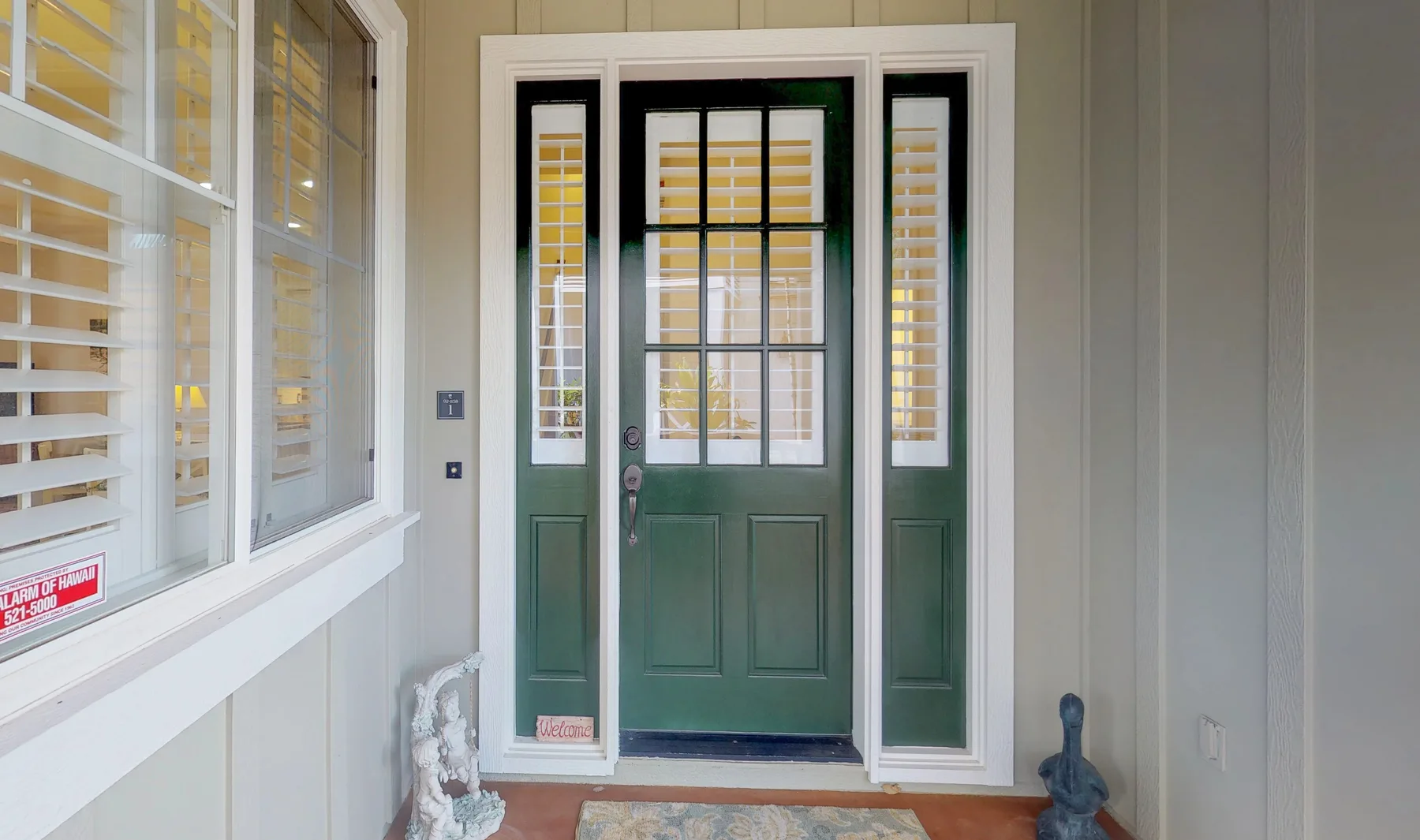 An entryway with a dark green door and tall windows.