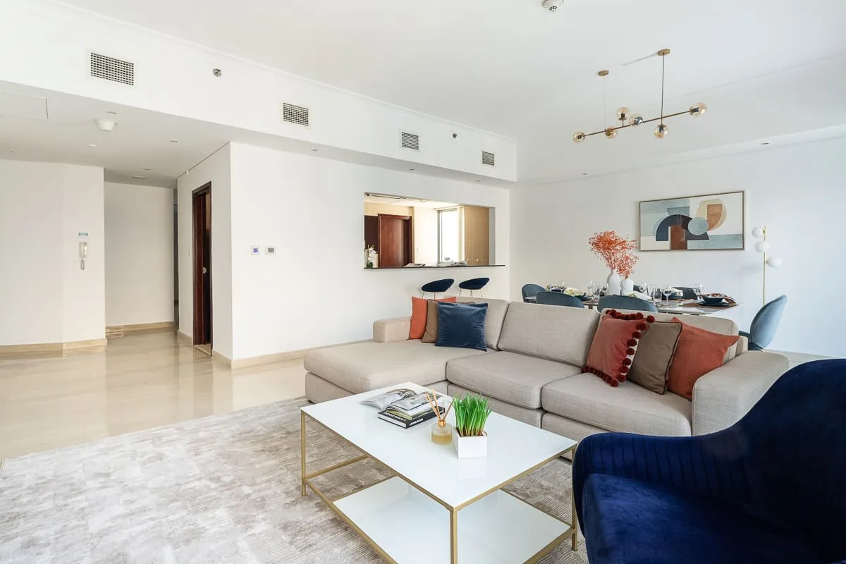 Una sala luminosa con un área de estar y una mesa de centro.