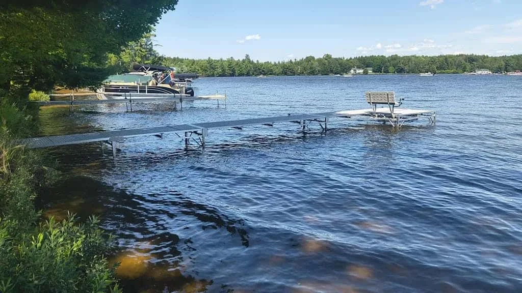 Un muelle junto al lago se extiende sobre el agua bajo un cielo despejado.