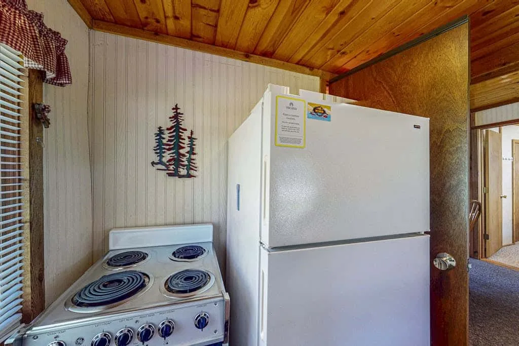 Un rincón de cocina con una estufa eléctrica y un refrigerador.