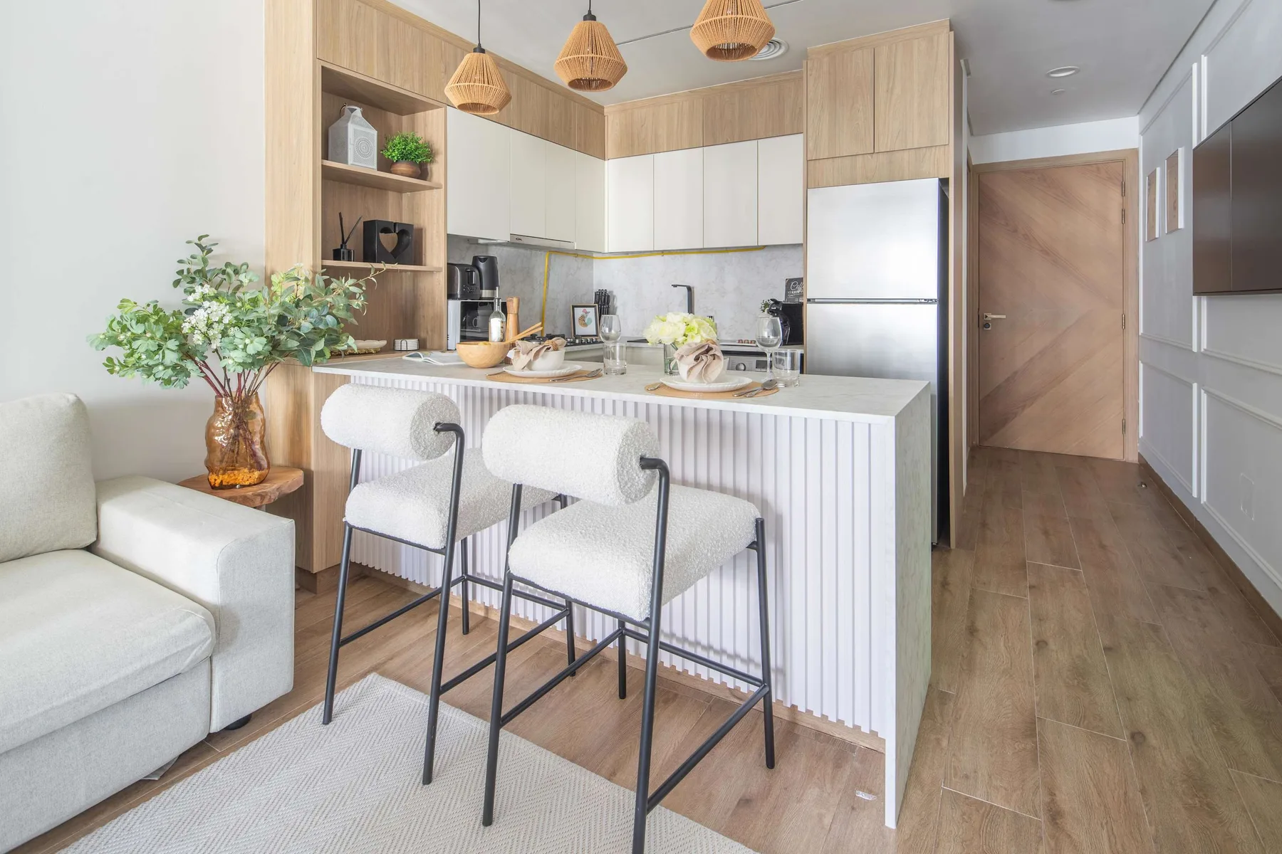 Una luminosa cocina-comedor de planta abierta con barra y asientos.