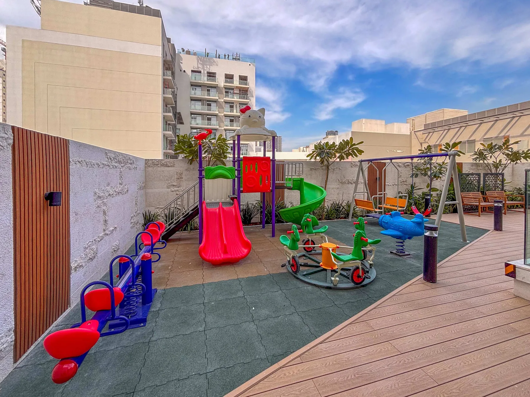 Un parque infantil al aire libre con toboganes de colores, juguetes para montar y columpios.