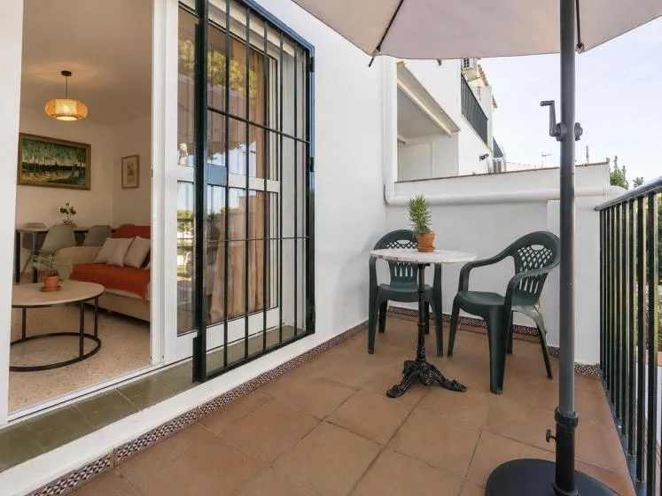 A tiled terrace with a small table and seating beside an open living area.