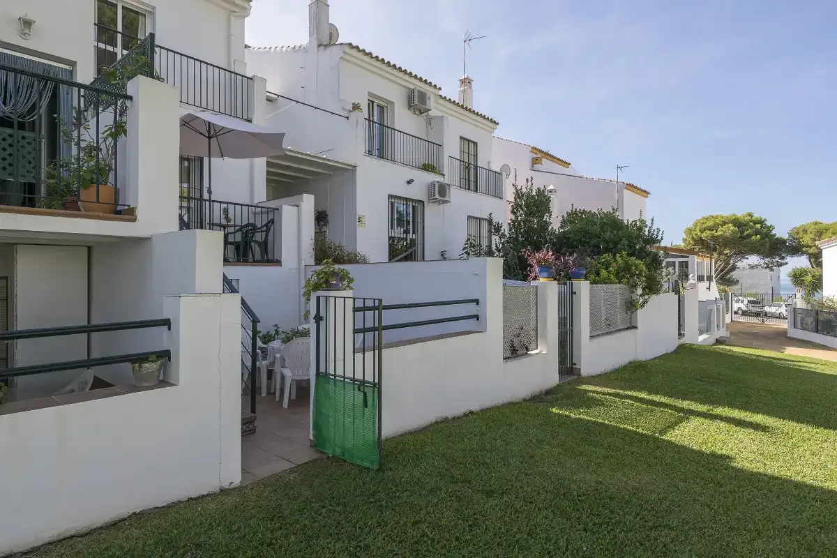 White residential buildings with balconies line a grassy outdoor area.