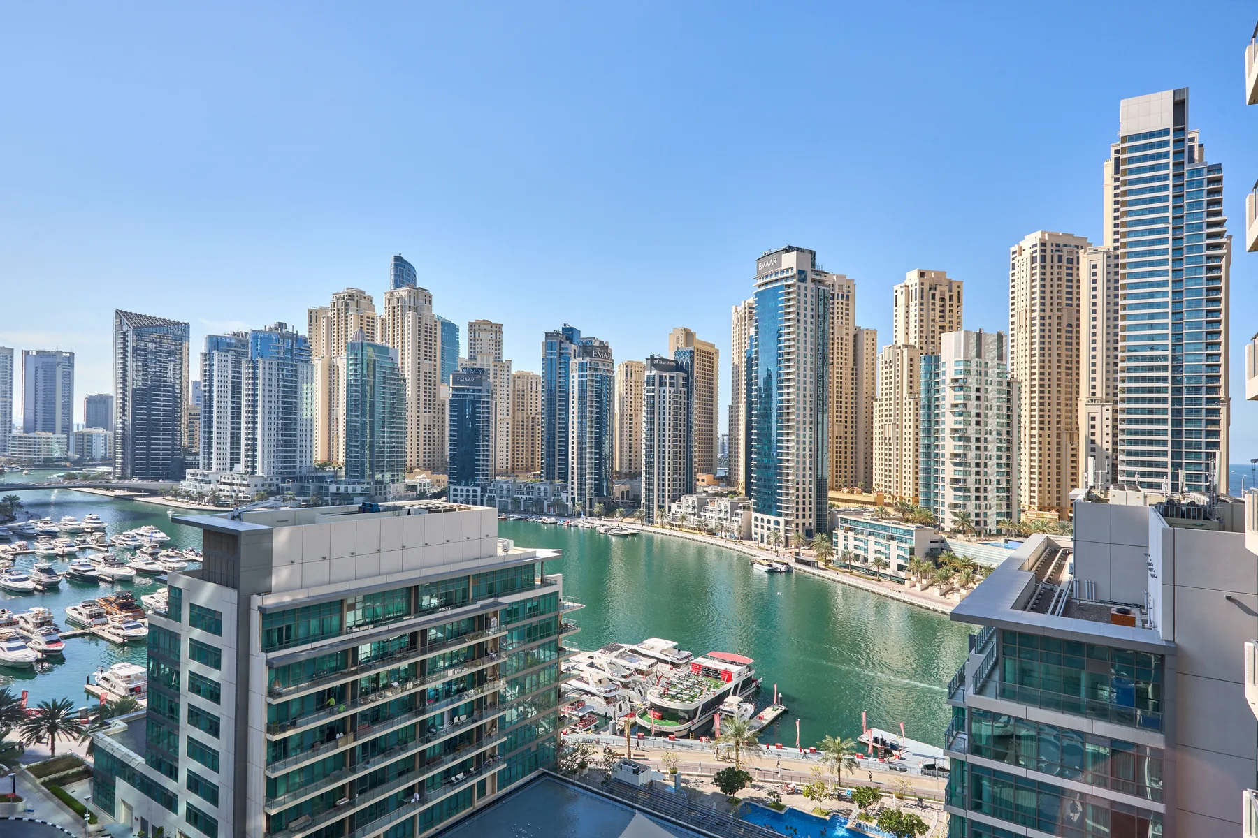 Un horizonte urbano se alza sobre un puerto deportivo y un canal estrecho.