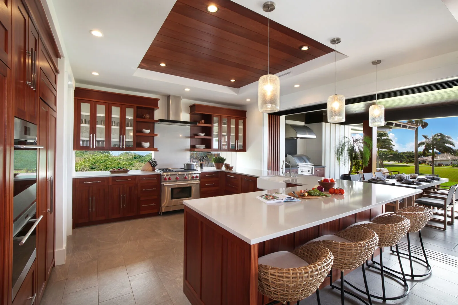 A spacious kitchen with a large island and dining area beside the windows.