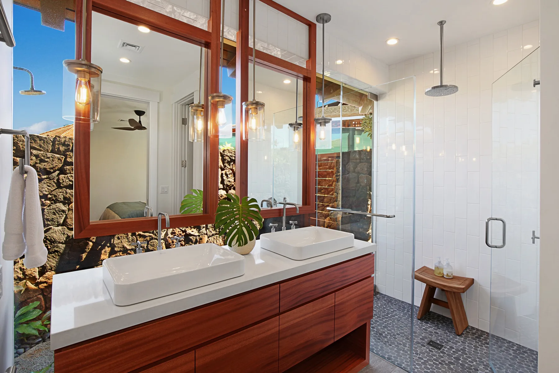A modern bathroom with a double vanity and a glass-enclosed shower.