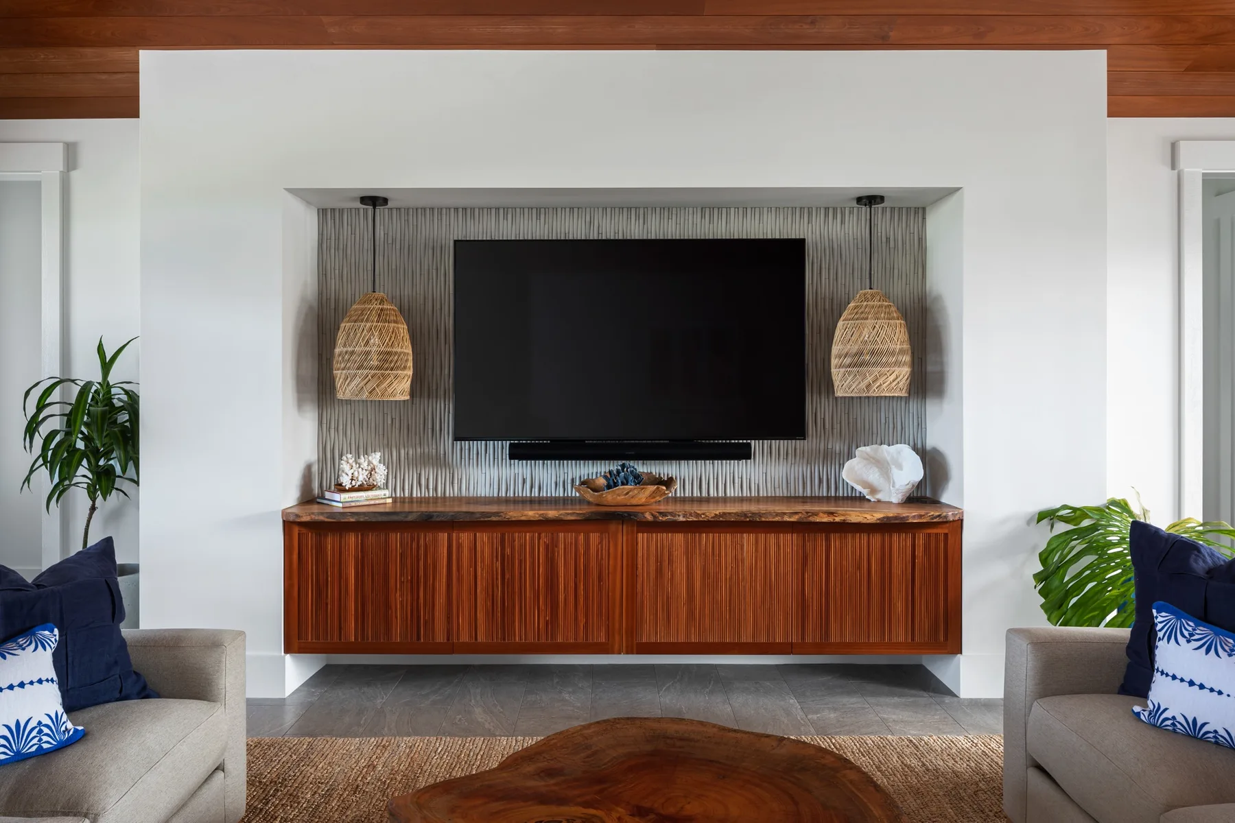 A living room entertainment wall features a television above a wooden cabinet.