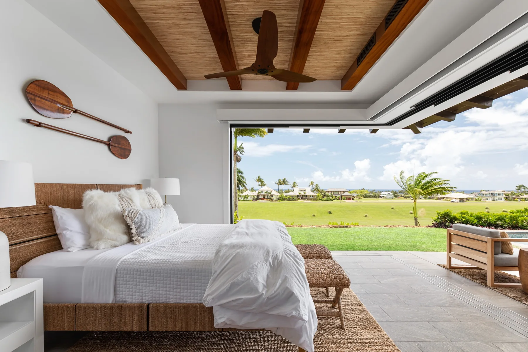 A bedroom opens onto a patio and a broad green lawn.