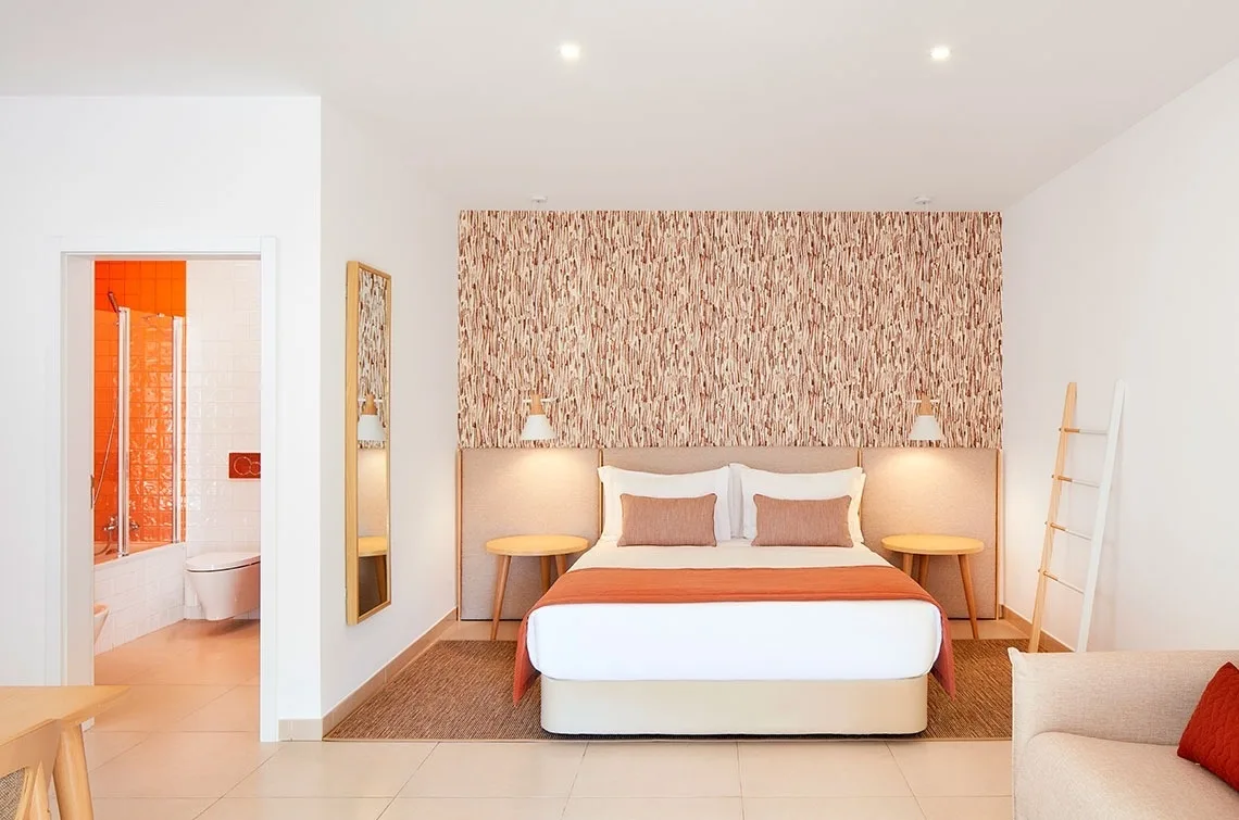 Double room with wood-effect wall covering and yellow throw.