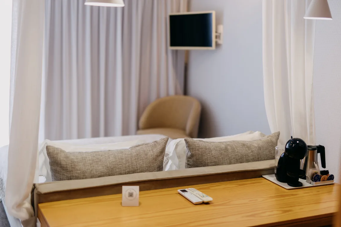 Guest room with a canopy bed, artwork and wood details.